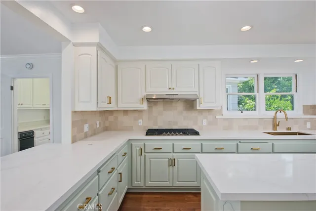 a kitchen with kitchen island a sink stainless steel appliances and cabinets