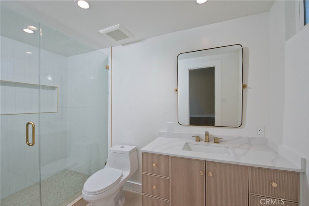 4722 Forman Lane Toluca Lake, CA 91602 - Photo 25 of 52 a bathroom with a toilet a sink a vanity and mirror