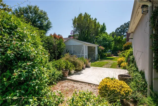 a front view of house with yard and trees around