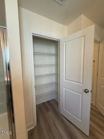 a view of walk in closet with empty racks