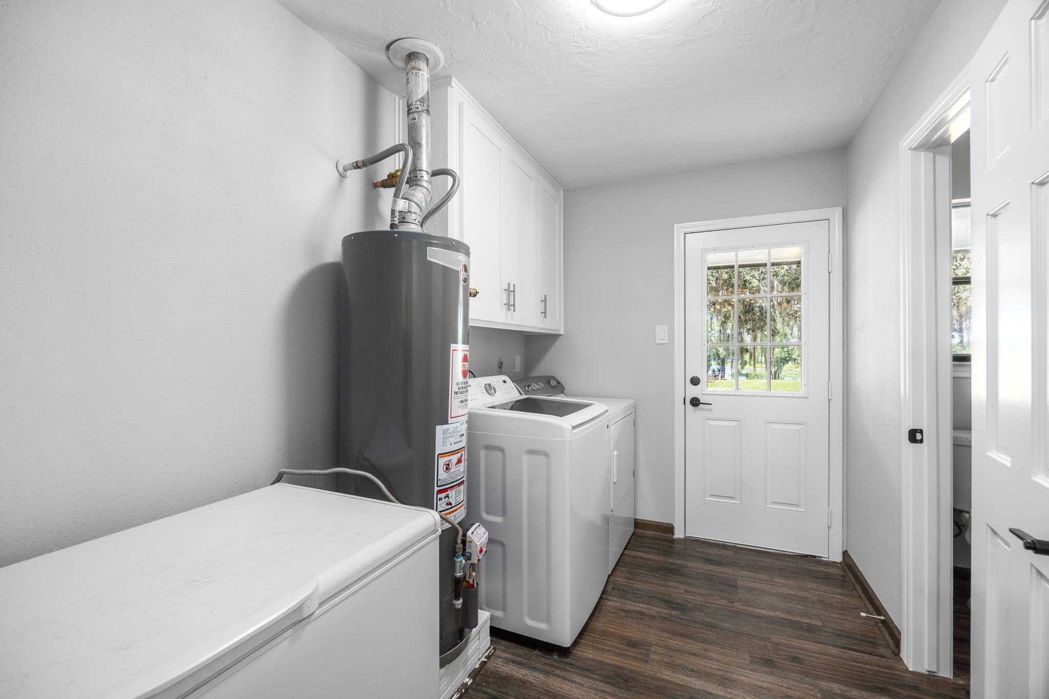 21802 Lake View Road Damon, TX 77430 - Photo 25 of 49 A spacious utility room with extra storage and convenient outdoor access makes everyday chores a breeze.