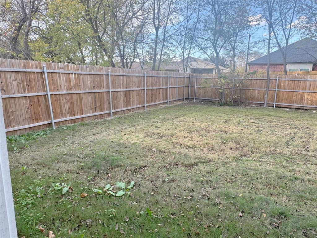 3912 Oneal Street Greenville, TX 75401 - Photo 18 of 20 a backyard of a house with a small yard and tree