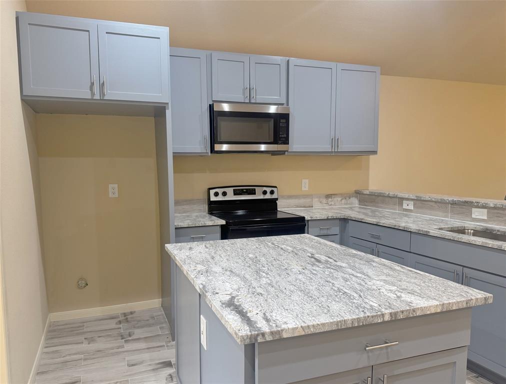 3912 Oneal Street Greenville, TX 75401 - Photo 4 of 20 a kitchen with granite countertop cabinets and steel stainless steel appliances