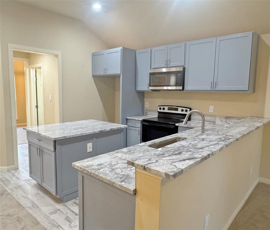 3912 Oneal Street Greenville, TX 75401 - Photo 5 of 20 a kitchen with granite countertop a sink a stove and refrigerator