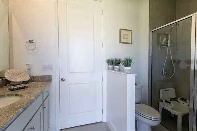 a bathroom with a granite countertop sink toilet and shower