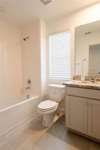 a bathroom with a granite countertop toilet a sink and a bathtub