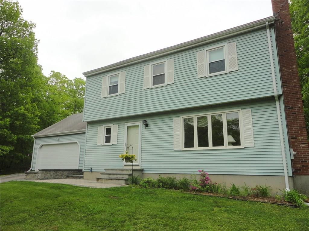 a front view of a house with a garden and yard