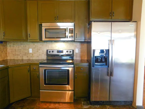 a kitchen with a refrigerator stove and microwave