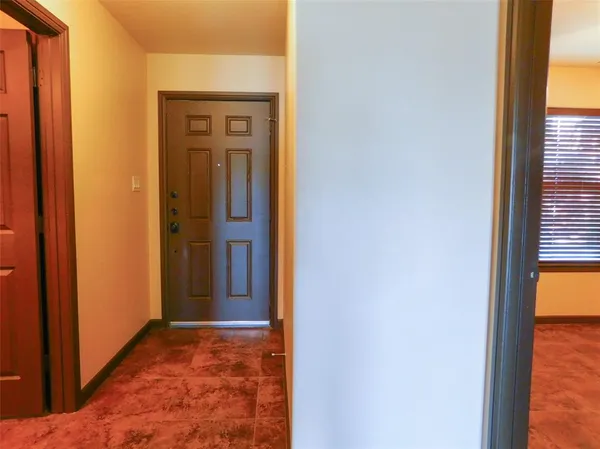 a view of a hallway with wooden floor and a dining room