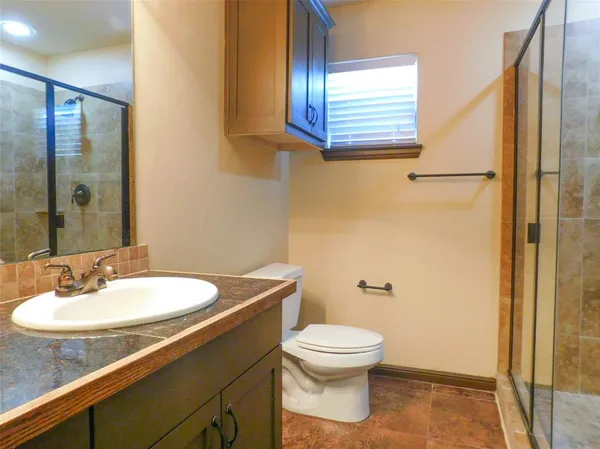 a bathroom with a sink a toilet and shower