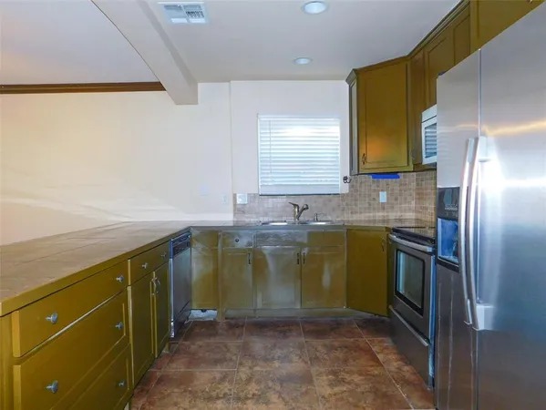 a kitchen with a sink appliances and cabinets