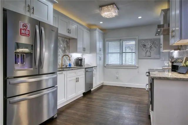 a kitchen with stainless steel appliances granite countertop a stove and cabinets