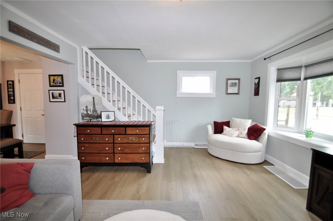 467 Cahoon Road Bay Village, OH 44140 - Photo 8 of 41 Living area with light wood finished floors, stairway, and ornamental molding