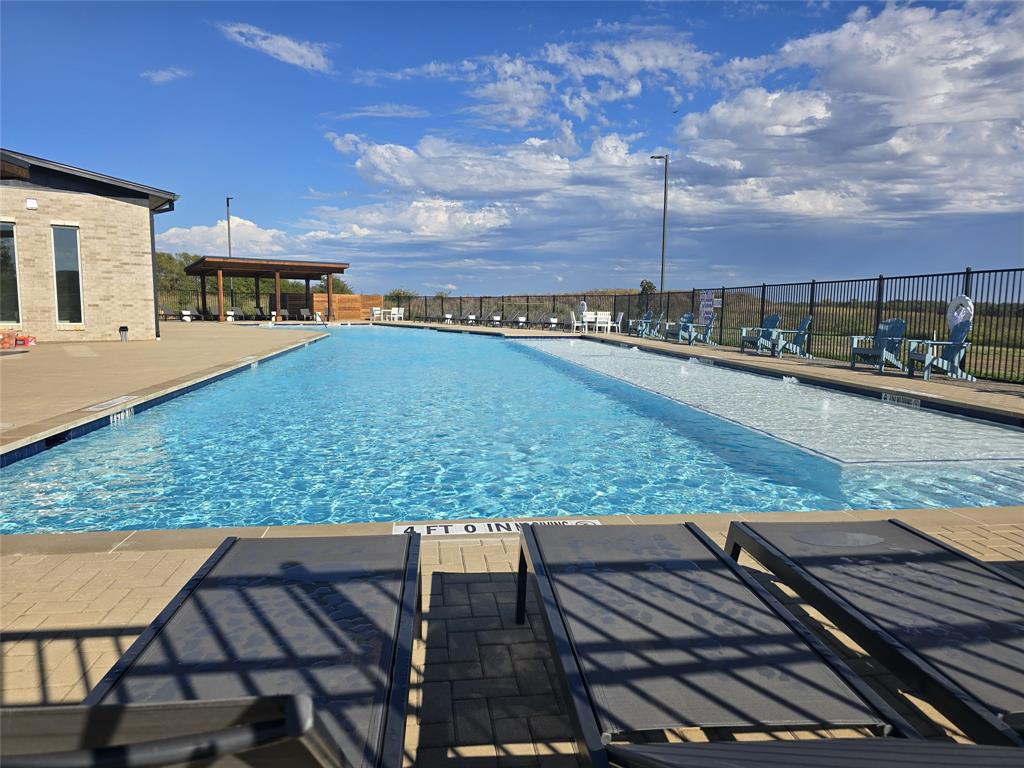 14017 Ilderton Street Pilot Point, TX 76258 - Photo 20 of 21 Expansive outdoor pool with a sun shelf, surrounded by paver decking