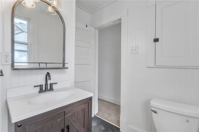 a bathroom with a sink a toilet and mirror