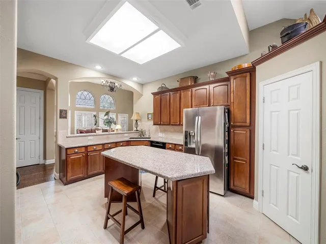 a kitchen with stainless steel appliances granite countertop a refrigerator and a stove top oven