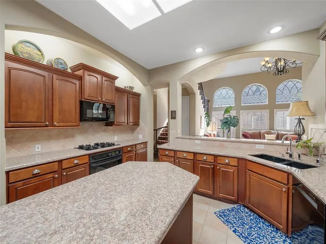 a kitchen with stainless steel appliances granite countertop a sink stove and cabinets