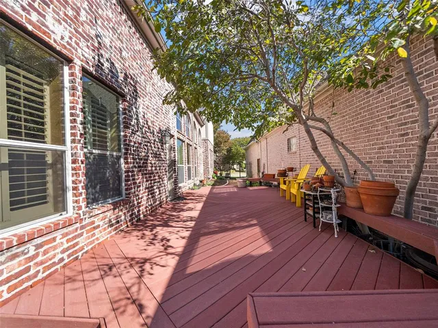 a view of a patio with table and chairs with wooden floor and fence