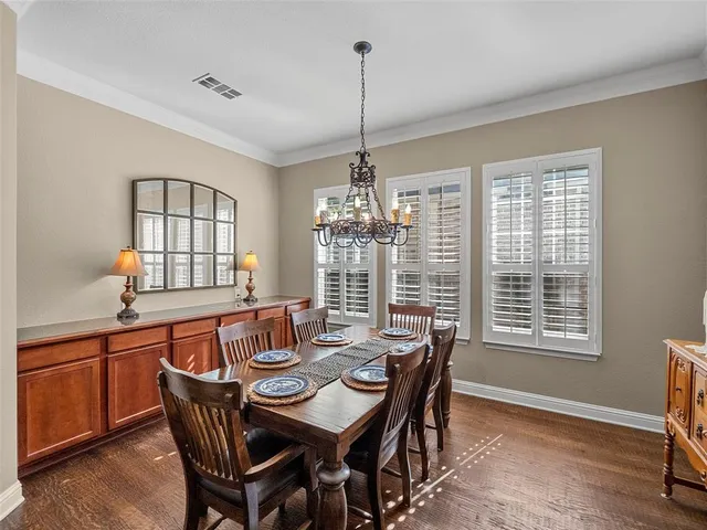 a dining room with furniture a chandelier and wooden floor