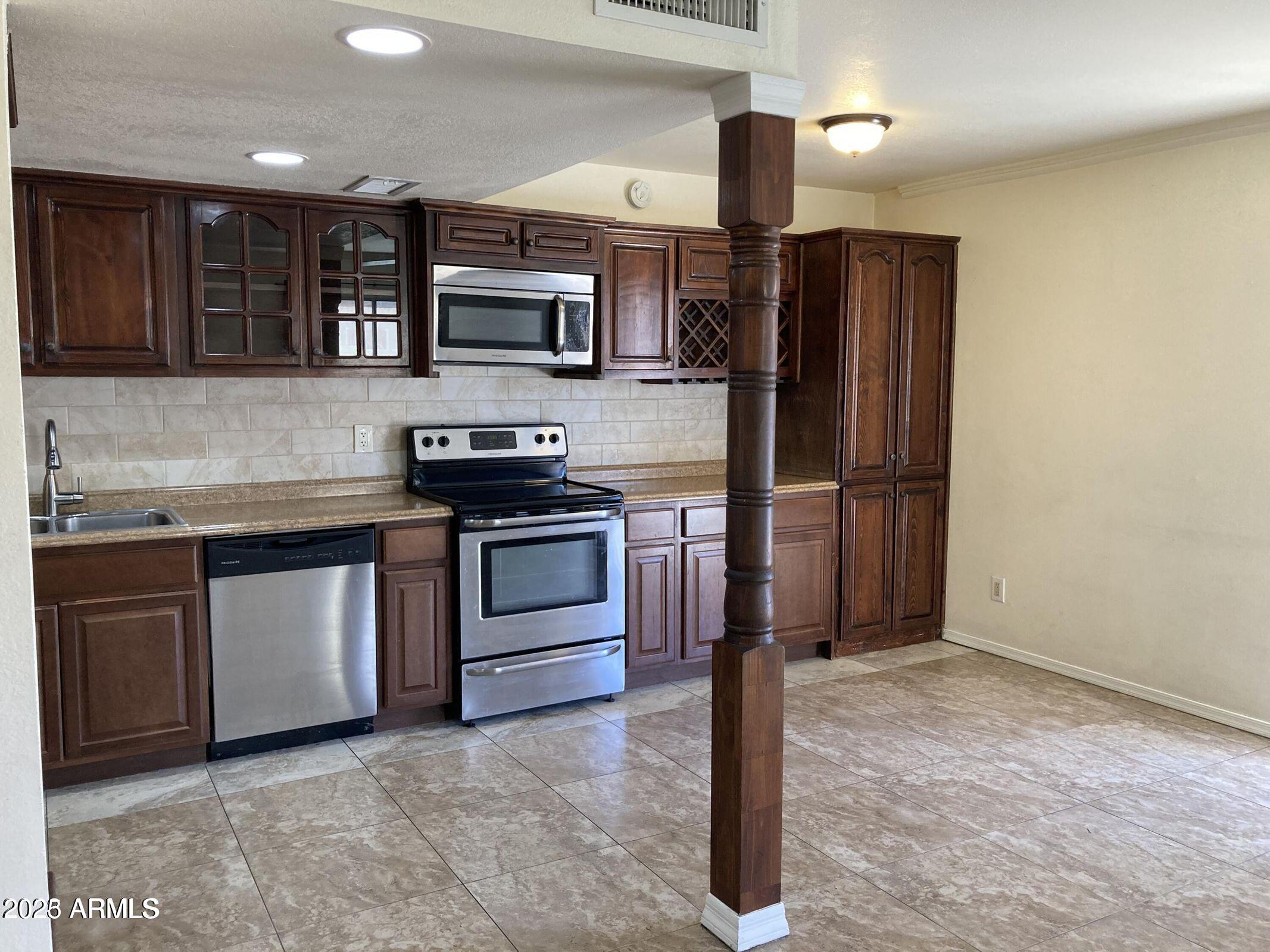 948 South Alma School Road, Unit 102 Mesa, AZ 85210 - Photo 1 of 13 a kitchen with stainless steel appliances granite countertop a refrigerator and a stove top oven