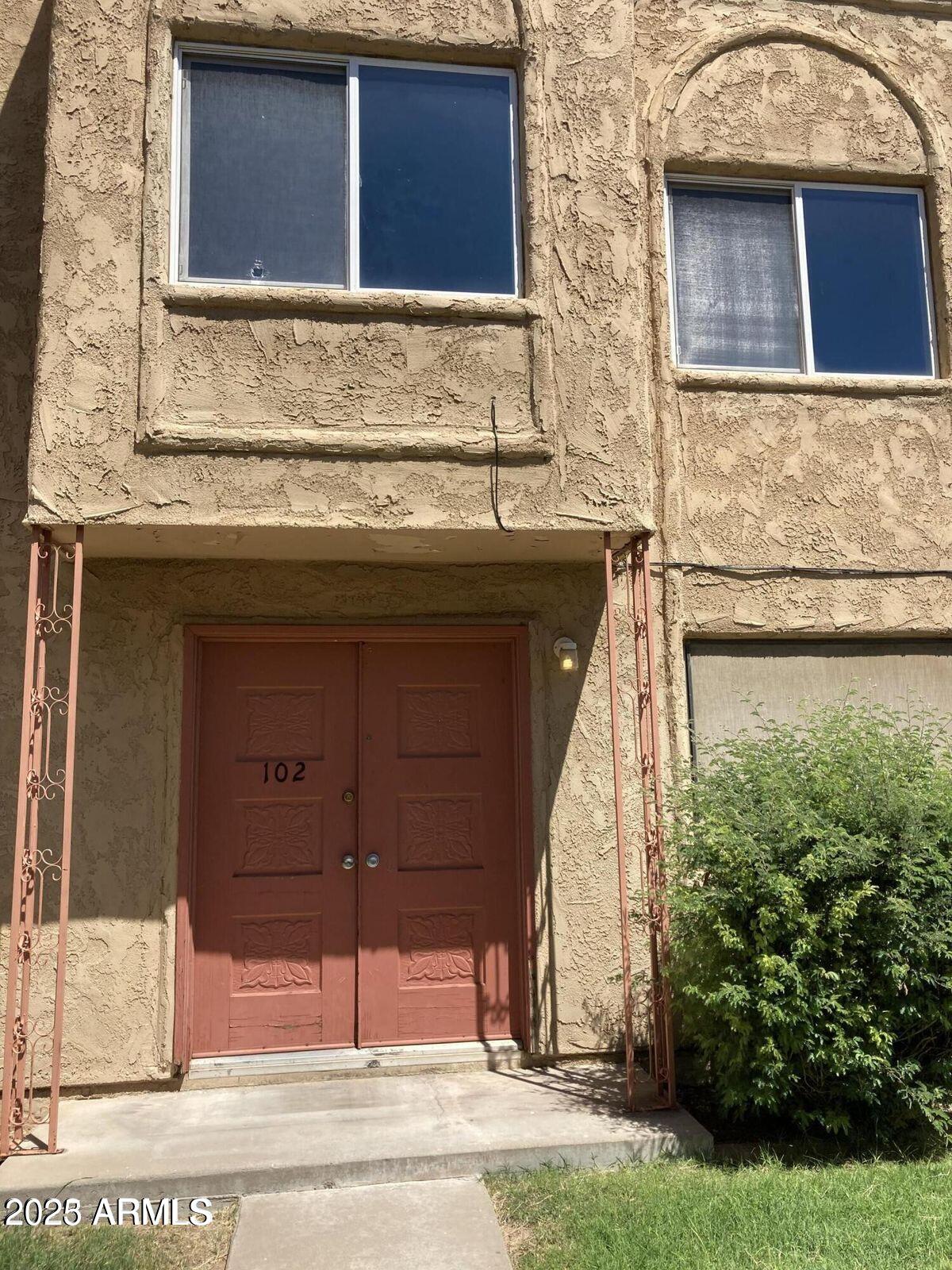 948 South Alma School Road, Unit 102 Mesa, AZ 85210 - Photo 13 of 13 a front view of a house with a yard and garage