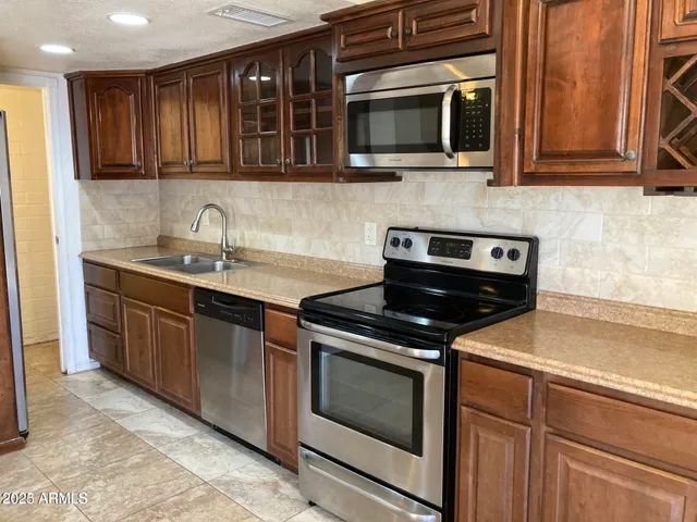 a kitchen with stainless steel appliances granite countertop a stove microwave and oven