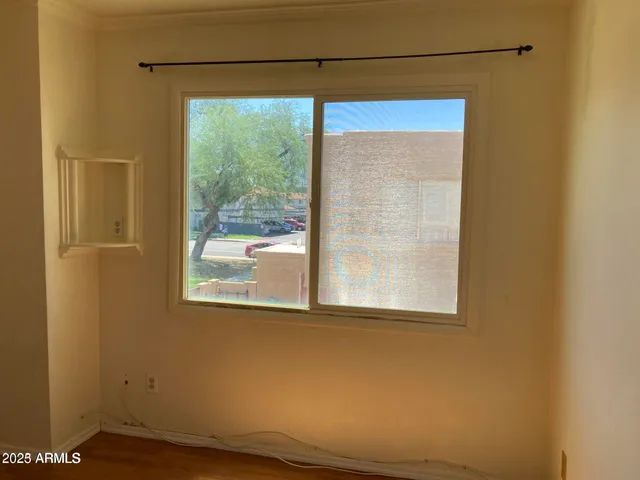 a view of a room that has a window and wooden floor