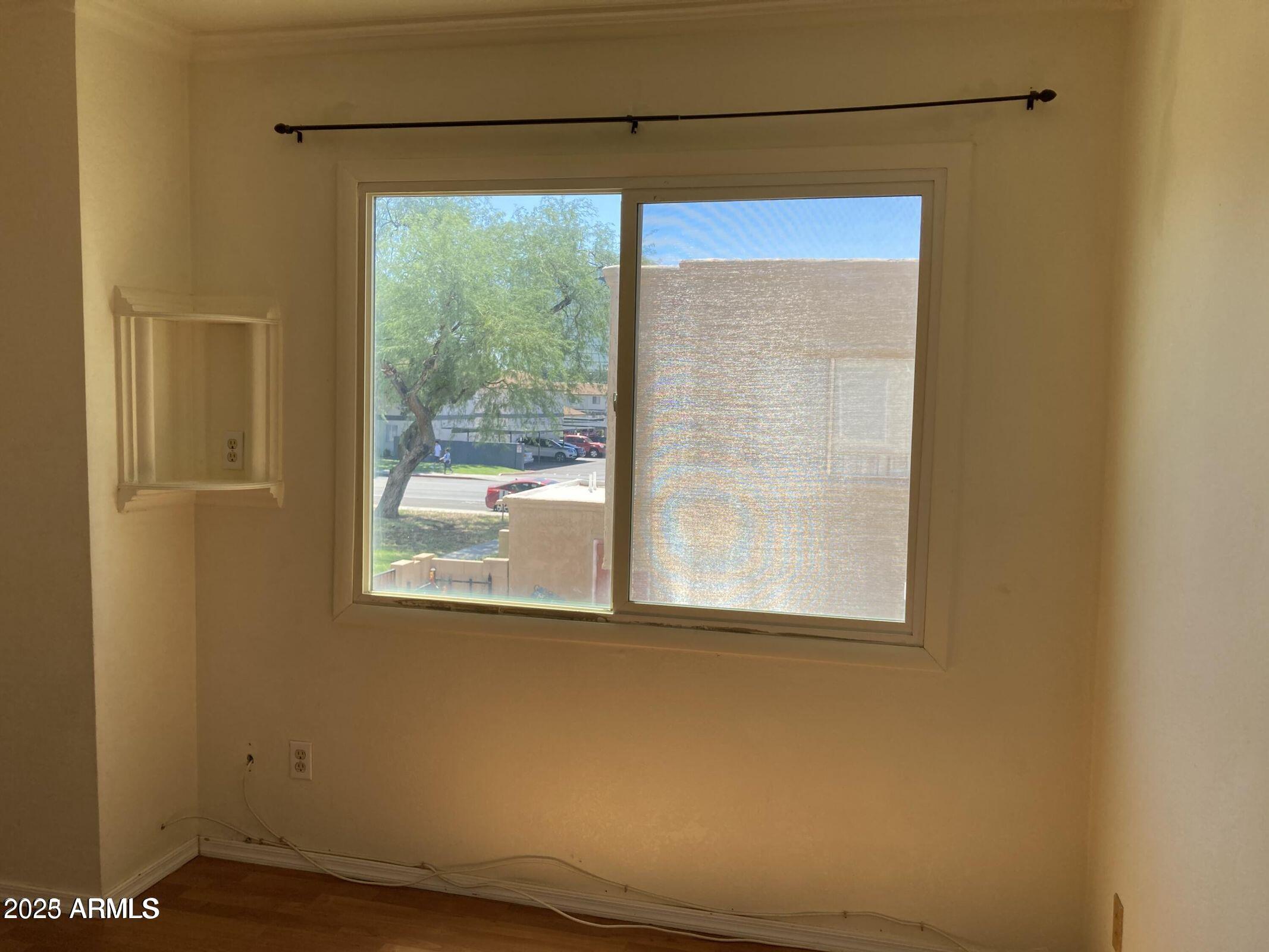948 South Alma School Road, Unit 102 Mesa, AZ 85210 - Photo 10 of 13 a view of a room that has a window and wooden floor