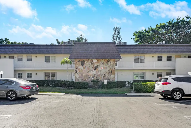 a view of building with cars parked in front of it