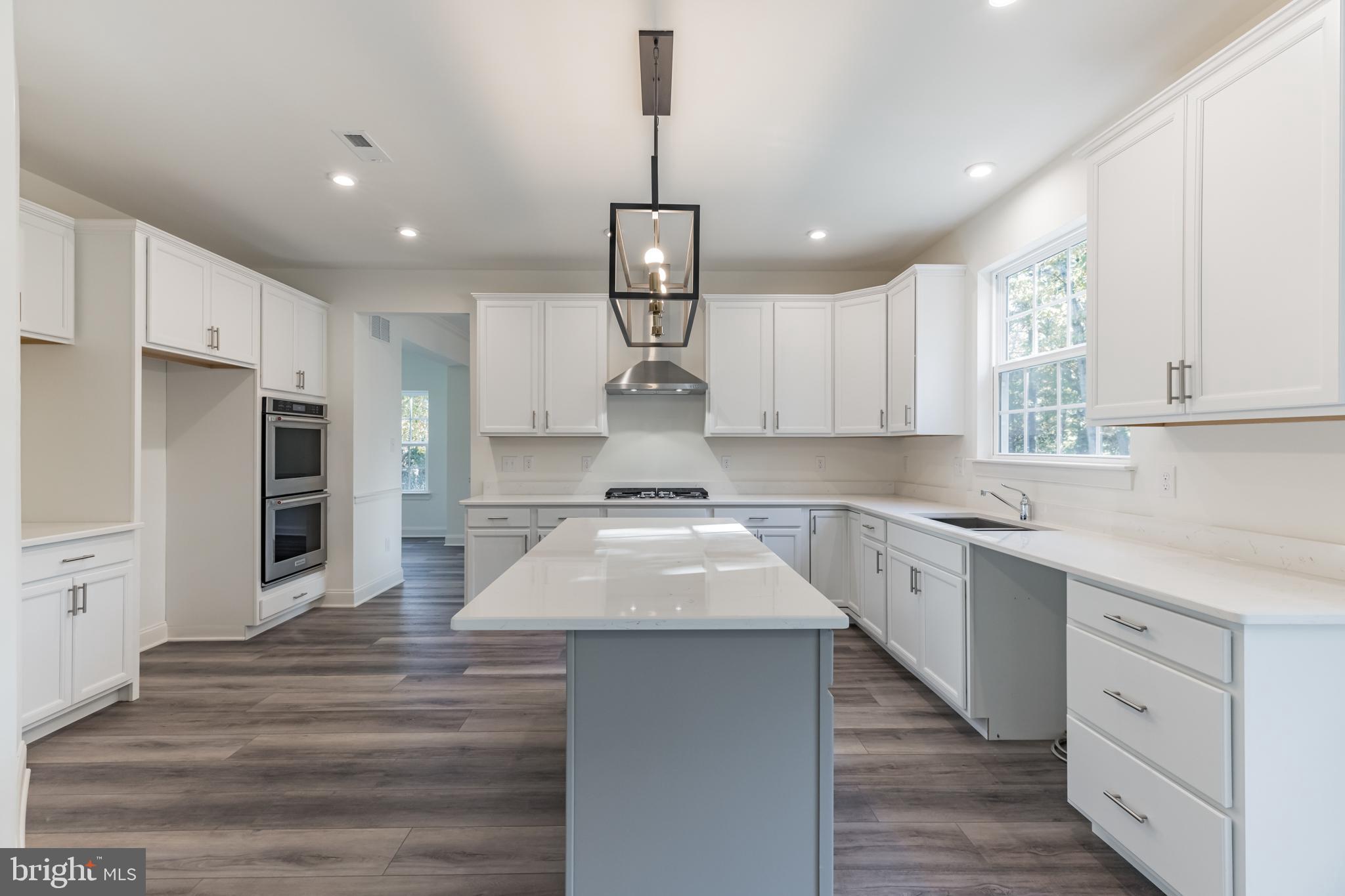 317 Ferrell Road Mullica Hill, NJ 08062 - Photo 12 of 31 a kitchen with kitchen island white cabinets stainless steel appliances and window