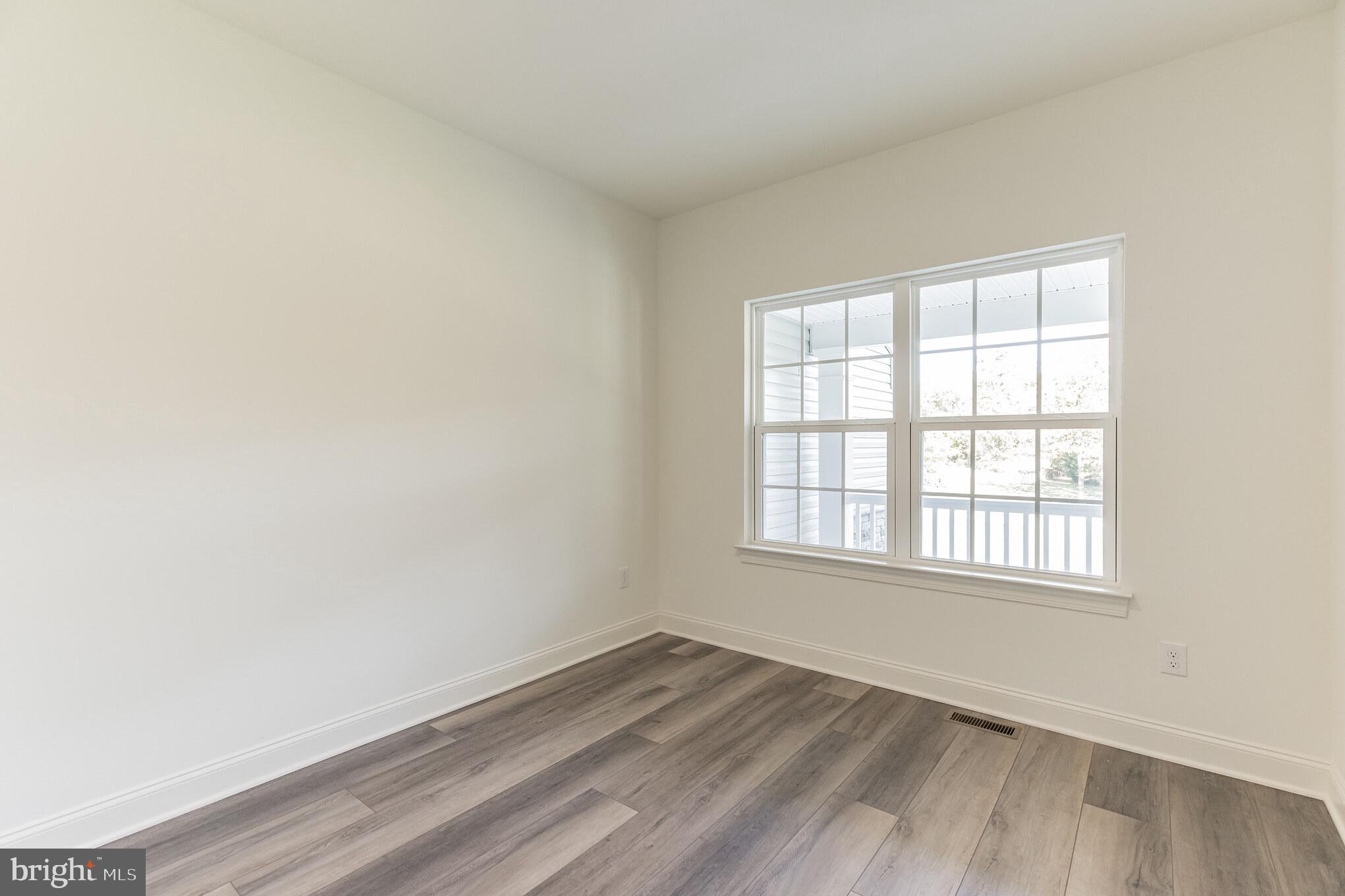 317 Ferrell Road Mullica Hill, NJ 08062 - Photo 4 of 31 an empty room with wooden floor and windows