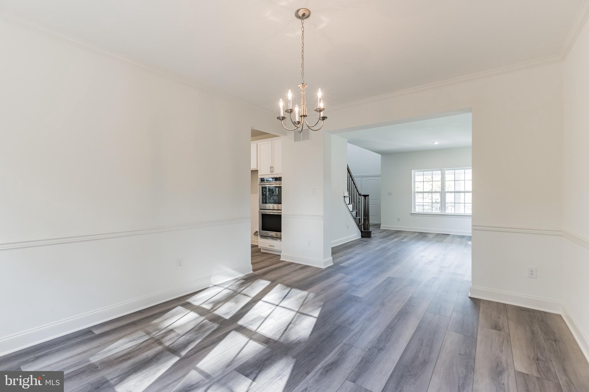 317 Ferrell Road Mullica Hill, NJ 08062 - Photo 8 of 31 a view of a room with wooden floor staircase and a kitchen