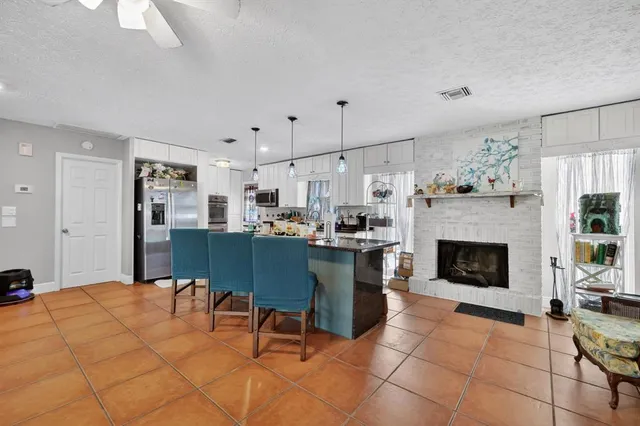 a living room with furniture a fireplace and kitchen view