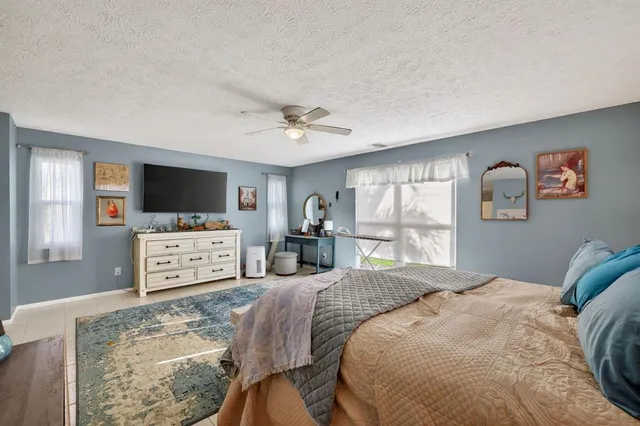 a bed room with a bed television and a window