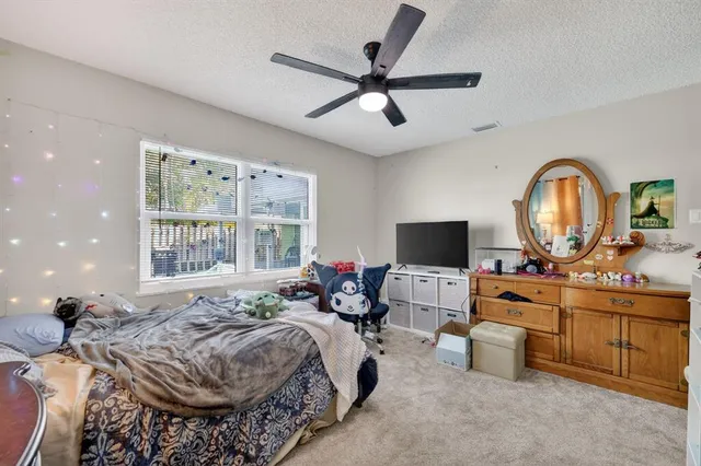 a bed room with a bed couches and a flat screen tv