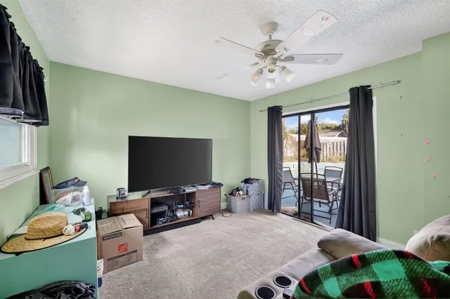 a bedroom with a bed and a flat tv screen on dresser