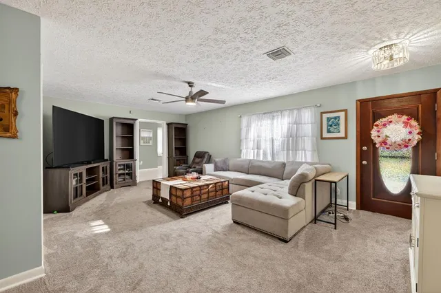 a living room with furniture a flat screen tv and a window
