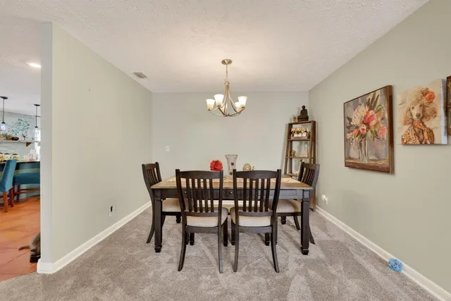 a view of a dining room with furniture and chandelier