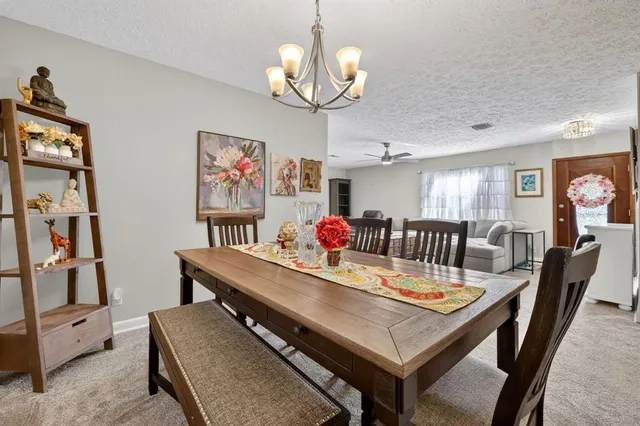 a view of a dining room with furniture and a chandelier
