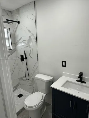 a bathroom with a granite countertop toilet sink and shower