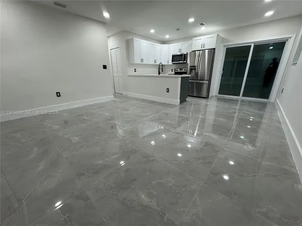 a view of kitchen with refrigerator and window