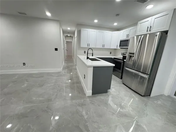 a kitchen with stainless steel appliances granite countertop a refrigerator a sink and a stove