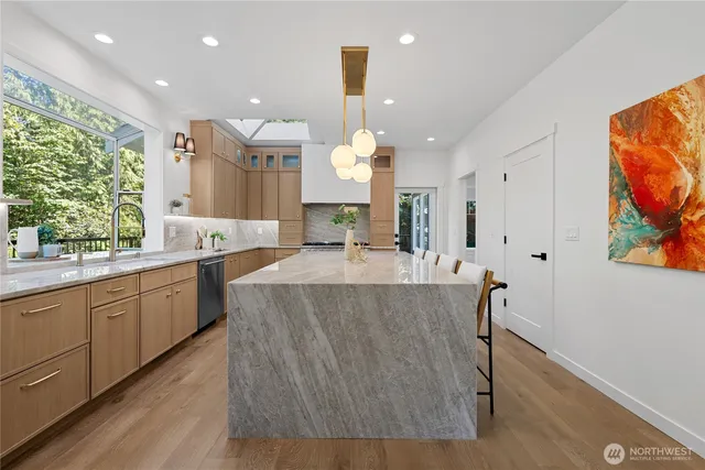 a large kitchen with stainless steel appliances a large counter top a refrigerator and a sink