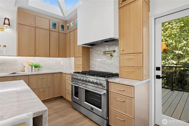 a kitchen with granite countertop a stove and white cabinets