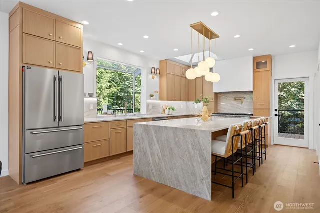a kitchen with kitchen island wooden floor center island and stainless steel appliances