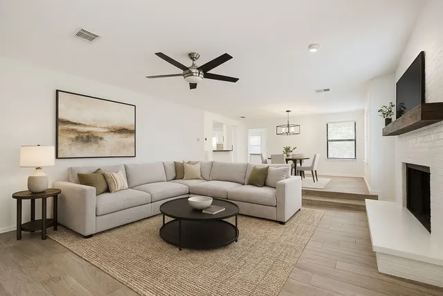 a living room with furniture a fireplace and a flat screen tv