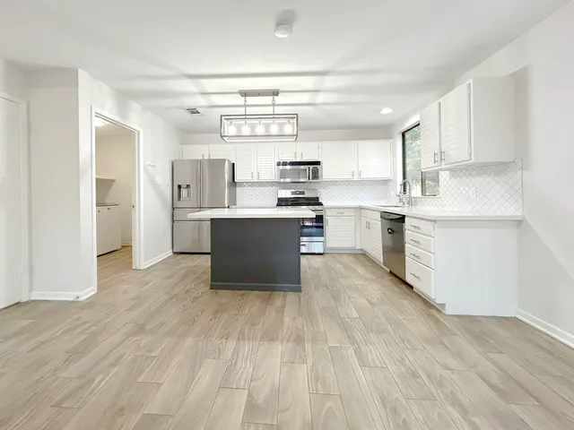a kitchen with stainless steel appliances granite countertop a sink and cabinets