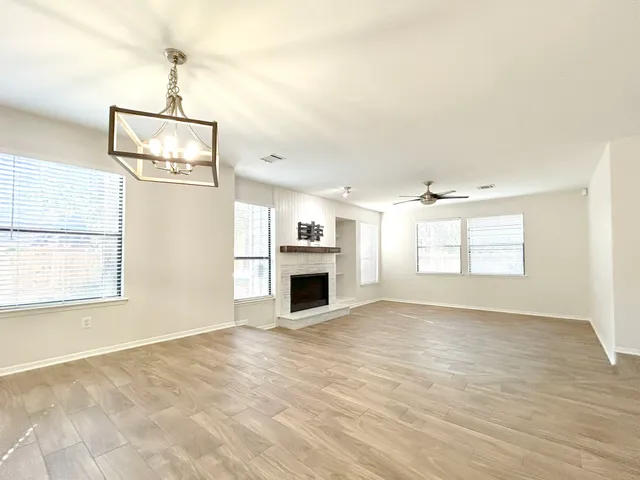 an empty room with windows and fireplace
