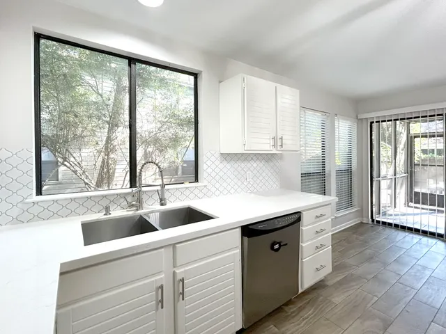 a kitchen with a sink and large window