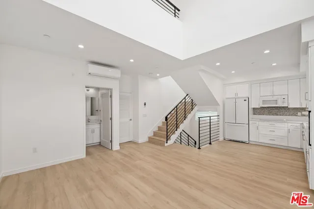 a view of a kitchen with wooden floor and a sink
